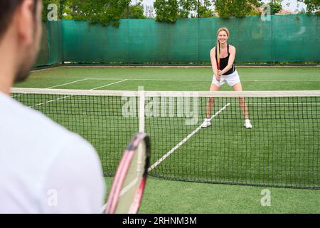 Mann und Frau spielen Tennis auf dem Tennisplatz, Leute in Sportbekleidung Stockfoto