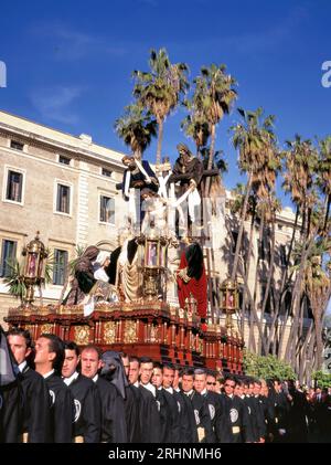 MALAGA, SPANIEN-APRIL,08 2012: Eine Gruppe von Trägern (Costaleros genannt), die einen religiösen Festwagen (bekannt als Tronos) in den Prozessionen trugen, die zum Feiern abgehalten wurden Stockfoto