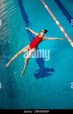 Erfahrene Sportlerin, die Seesterne im Swimmingpool schwimmt Stockfoto