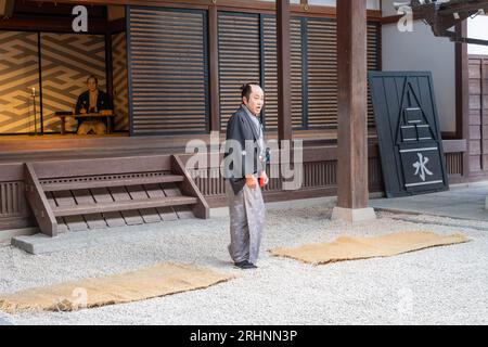 Ein Mann, der in einem historischen Kostüm eines hochkarätigen Saumrai mit einem Spitzenknoten gekleidet ist und in einem Kimono in einem Comedy-Stück aus der edo-Zeit im Edomura Wonderland spielt. Stockfoto