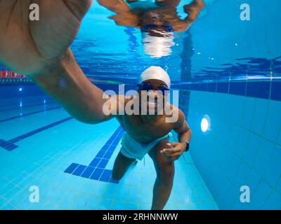 Schwimmer, der sein Unterwasser-Training im Schwimmbad genießt Stockfoto