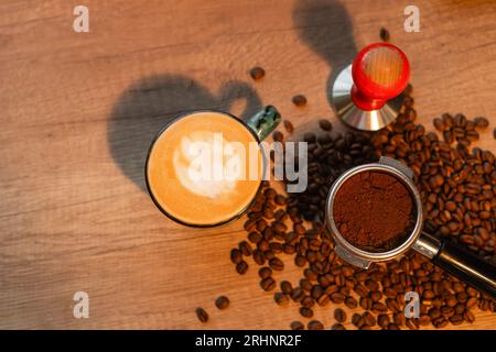 Blick von oben auf Cappuccino, Presse und Kaffeebohnen mit Beleuchtung im Coffee Shop Stockfoto