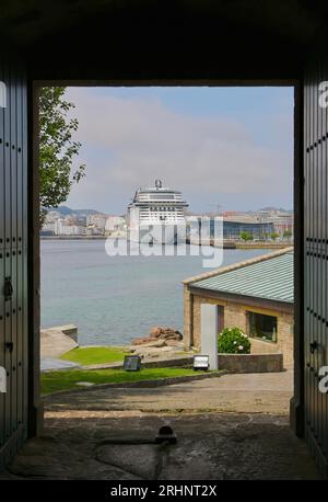 Blick durch die Türen am Eingang zum Schloss San Anton mit dem Passagierschiff MSC Virtuosa, das im Hafen von A Coruña Galicien Spanien liegt Stockfoto