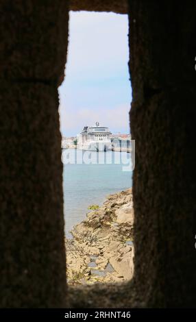 Blick durch einen Pfeilschlitz auf die Burg San Anton des Passagierschiffs MSC Virtuosa, das im Hafen von A Coruña Galicien Spanien liegt Stockfoto