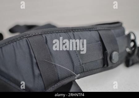Schwarzer Hosenträger oder Gürtel, elegantes und hochwertiges Accessoire, das Ihren Stil abrundet. Konzept für Rucksäcke oder Militärzubehör. Stockfoto
