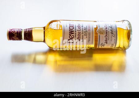 Moskau, Russland - 2. August 2022: Liegende Flasche Dewar's White Label Scotch Whisky auf hellem Tisch. Dieser Blended Whisky wurde von John Dewar & Sons kreiert Stockfoto