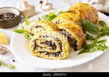 Vegetarisches, köstliches Essen. Zucchini-Brötchen (Roulade) mit Käse und Pilzen auf einer Marmorplatte. Stockfoto