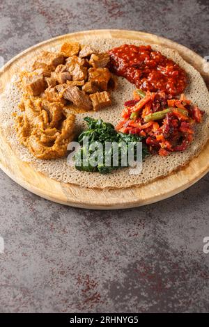 Das Essen besteht aus Injera und verschiedenen Arten von Wat- oder Tsebhi-Eintopf und ist typisch für die äthiopische Küche. Vertikal Stockfoto