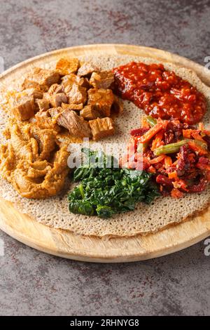 Injera firfirfirr Fladenbrot typisch äthiopisches Frühstück Essen aus nächster Nähe auf dem Holzbrett. Vertikal Stockfoto