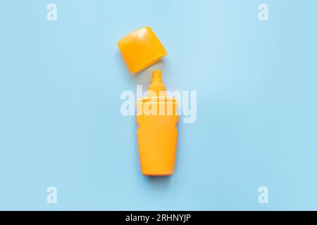 Sonnenschutzmittel, orangefarbene Flasche, Sonnenschutz auf blauem Hintergrund. Spray zum Schutz vor Sonnenbrand. Stockfoto