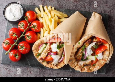 Gyros Souvlaki in einem Pitabrot auf dem Brett auf dem Tisch verpackt. Horizontale Draufsicht von oben Stockfoto