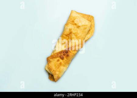 Frisches Hühnerbrötchen mit frischen Tomaten, Salat, Käse und Zwiebeln auf hellblauem Hintergrund. Draufsicht. Stockfoto