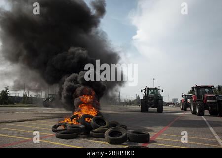 Brüssel, Belgien. August 2023. Die Abbildung zeigt brennende Autoreifen während eines Protestes gegen ein neues Industriewerk von Ineos in Antwerpen, Freitag, den 18. August 2023. Die kollektive 'Farmers Defence Force' (FDF) ist heute mit rund tausend Unterstützern auf dem Weg nach Antwerpen. Aus der Region Brecht und aus der Region Kempen kommen Unterstützer zu einem Protest im Park Spoor Oost. Sie entschieden sich speziell für Antwerpen, weil sie behaupten, N-VA würde den roten Teppich für Ineos' neue Fabrik hier ausrollen. BELGA PHOTO KRISTOF VAN ACCOM Credit: Belga News Agency/Alamy Live News Stockfoto