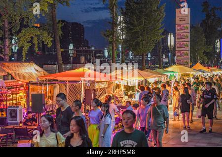 (230818) -- PEKING, 18. August 2023 (Xinhua) -- Menschen treffen sich auf einem Nachtmarkt im Bezirk Jiangbei, südwestchinesisches Chongqing, 4. August 2023. Chongqing, eine Stadt am Yangtze-Fluss, wird von den Chinesen wegen ihrer hohen Temperatur im Sommer als „Herd“ bezeichnet; Kairo, das sich am Ufer des Nils befindet, ist seit langem ein heißer Ort am Rande der Wüste. Beide Städte haben die Nachtwirtschaft energisch gefördert. Hongyadong in Chongqing ist ein altes Stadttor, das in ein riesiges hängendes Gebäude mit Restaurants und anderen Unterhaltungsmöglichkeiten verwandelt wurde. Khan el-Khalili in Stockfoto