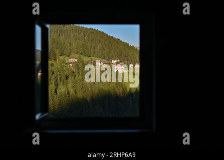 20. Juli 2023, Italien, Wolkenstein: Frühmorgendlicher Blick aus dem Fenster einer Wohnung auf die Landschaft der Dolomiten in Südtirol. Foto: Patrick Pleul/dpa Stockfoto