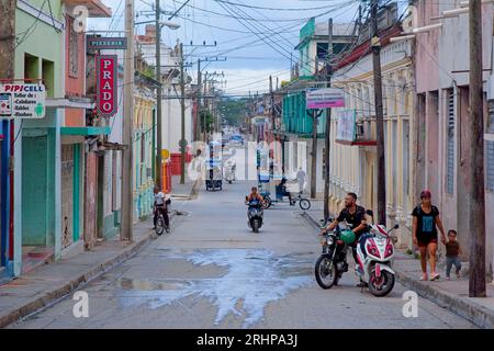 Havanna, Kuba - 27. Juli 2023: Menschen in einer Stadtstraße, in der Zeichen von kleinen Unternehmen zu sehen sind. Stockfoto