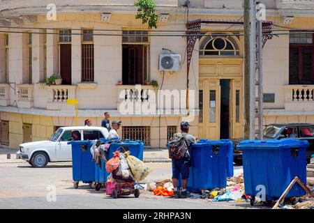 Havanna, Kuba - 27. Juli 2023: Menschen mit einem rustikalen Wagen suchen in den großen Straßenkorbbehältern Stockfoto