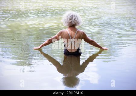 Ältere Frau, die im See badet Stockfoto