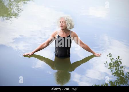 Ältere Frau, die im See badet Stockfoto