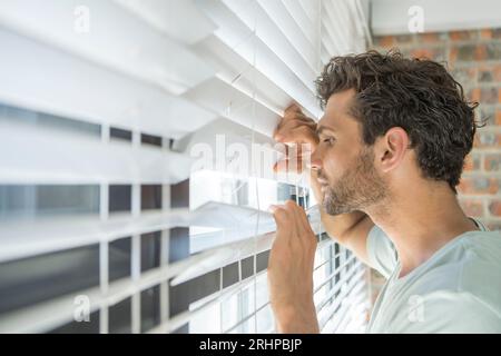 Der Mann schaut aus dem Fenster Stockfoto