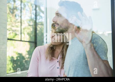 Das Paar sieht nachdenklich aus dem Fenster Stockfoto