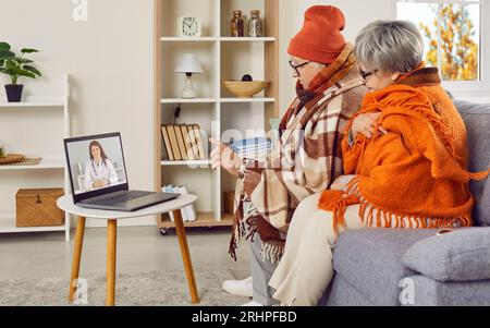 Kranke Seniorenpaare, die Empfehlungen hören, Online-Videoanrufe mit einem Arzt zu Hause zu führen. Stockfoto