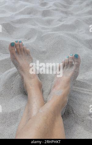 Deutschland, Ostsee, feiner Sand, Frauenfüße mit bemalten Zehennägeln Stockfoto