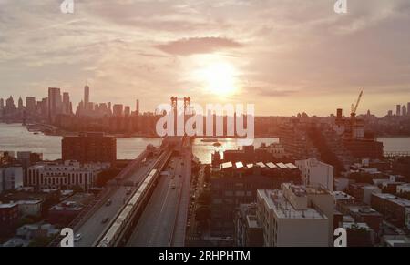 Die Williamsburg Bridge in New York City überquert den East River und bietet einen atemberaubenden Panoramablick auf Manhattan bei Sonnenuntergang. Stockfoto