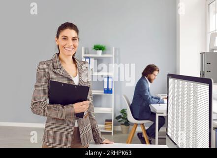 Porträt einer freundlich lächelnden Buchhalterin oder Finanzanalytikerin an ihrem Schreibtisch im Büro. Stockfoto