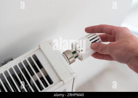 Thermostat am Kühler herunterdrehen, um Energie aufgrund der Erhöhung der Heizkosten zu sparen Stockfoto