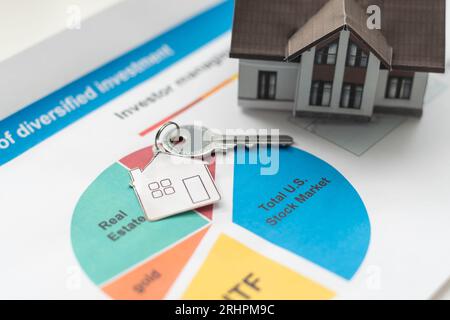 Orangefarbene Dachhäuser und Schlüssel, die auf Diagrammen oder Geschäftsdaten platziert werden. Ideen für Geschäftswachstum, Wirtschaftsdiagramme, Immobilienmärkte, Hypotheken, Haussteuern Stockfoto