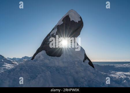 Die Sonne scheint durch das Loch in den Felsen, Lofoten, Norwegen, Winter Stockfoto