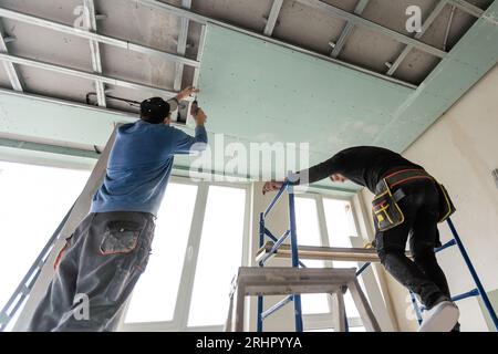 Drywall Installers. Men holding a gypsum board figured cut Stockfoto