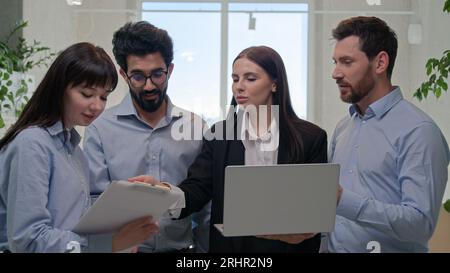 Team Berufstätige Geschäftsleute Geschäftsleute und Geschäftsfrauen Gruppe von Mitarbeitern Unternehmensmitarbeiter sprechen im Büro diskutieren Projekt auf Laptop Stockfoto