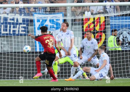 18. August 2023, Hessen, Wiesbaden: Fußball: 2. Bundesliga, SV Wehen Wiesbaden - Karlsruher SC, Spieltag 3, BRITA-Arena. Kianz Froese (l) trifft Robin Bormuth vom Karlsruher SC aus nächster Nähe auf den Arm, aber Schiedsrichter Haslberger (nicht abgebildet) nennt keinen Elfmeterstoß. Foto: Jürgen Kessler/dpa - WICHTIGER HINWEIS: Gemäß den Anforderungen der DFL Deutsche Fußball Liga und des DFB Deutscher Fußball-Bund ist es verboten, im Stadion und/oder im Spiel aufgenommene Fotos in Form von Sequenzbildern und/oder videoähnlichen Fotoserien zu verwenden oder zu verwenden. Stockfoto