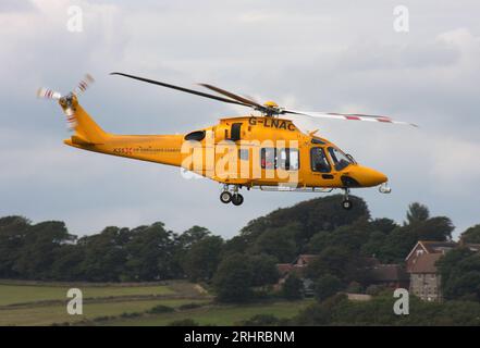 Ein AW-169-Rettungswagen des Kent Surrey Sussex Trust verlässt den Brighton City Airport mit einem Cessna 510 Citation Business Jet im Vordergrund. Stockfoto