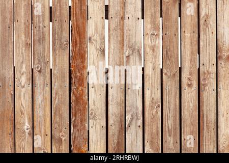 Vertikaler Zaun aus Holzplatten. Gebrauchte Holzpaneele. Alter Hartholzhintergrund. Stockfoto