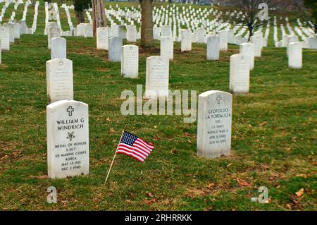 Eine kleine amerikanische Flagge weht zwischen den zahlreichen Gräbern verstorbener Veteranen auf dem Arlington National Cemetery in der Nähe von Washington DC Stockfoto