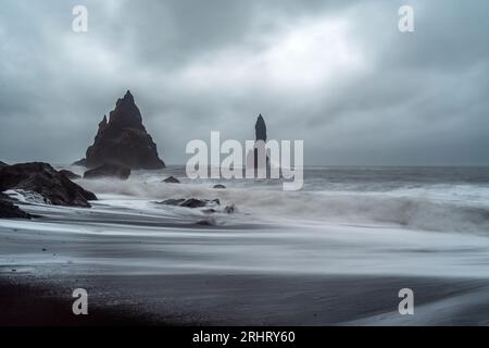 Black Sand Beach in Island. Weiße Wellen stürzen auf die inky isländische Küste und erzeugen holographische Muster auf dem tiefschwarzen Sand Stockfoto