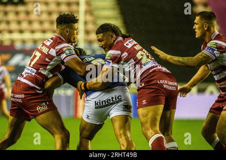 Kai Pearce-Paul und Patrick Mago kämpfen gegen Chris Satae vom FC Hull während des Spiels der Betfred Super League zwischen Wigan Warriors und Hull Football Club im DW Stadium, Wigan am Freitag, den 18. August 2023. (Foto: Ian Charles | MI News) Credit: MI News & Sport /Alamy Live News Stockfoto