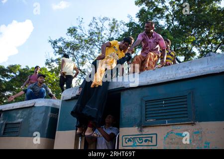 Heimreisende kämpfen darum, die Dachterrasse eines Zuges am Flughafen-Bahnhof in Dhaka vor Eid-ul-Azha zu bekommen. Dhaka, Bangladesch. Stockfoto