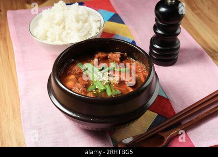 Eine Schüssel mit heißer veganer, würziger koreanischer Kimchi-Eintöpfsuppe oder Kimchi Jigae, serviert mit gedämpftem Reis Stockfoto