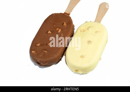 Eis mit Vanillegeschmack in knackiger brauner und weißer Milchschokolade und gerösteten Mandeln, Vanillescheisstangen, beschichtet und mit einer Schicht bedeckt Stockfoto