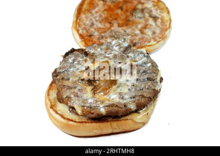 Doppelt saftiges, dickes Rinderpatty mit Käse, der mit Sauce bedeckt ist, Pilzen in einem großen Sesambrötchen, ein Hamburger-Sandwich mit Rindfleisch und spezieller Sauce Stockfoto