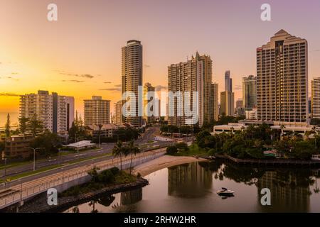 Ein spektakulärer Sonnenaufgang erleuchtet die Surfers Paradise Hochhauswohnungen mit schönem goldenen Licht. Grenzt an das Meer und die Kanalentwicklung. Stockfoto