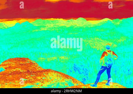 Der Läufer bleibt am Aussichtspunkt. Wandern in Waldbergen. Fantastisches Thermografie-Foto der hügeligen Landschaft. Stockfoto