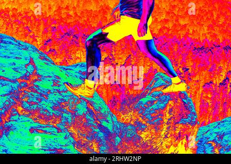 Lange Beine in Wanderschuhen auf dem Gipfel. Wandern in Sandsteinfelsen. Fantastisches Thermografie-Foto der hügeligen Landschaft. Stockfoto