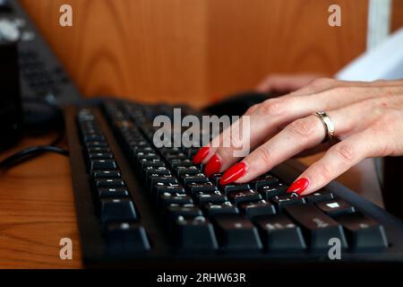 Die Bürodame fingerte in der Nähe an den Computer oder die schwarze Tastatur des Laptops Stockfoto