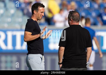 18. August 2023, Hessen, Wiesbaden: Fußball: 2. Bundesliga, SV Wehen Wiesbaden - Karlsruher SC, Spieltag 3, BRITA Arena. Vor Spielbeginn freundschaftliches Gespräch zwischen Trainer Christian Eichner (l) vom Karlsruher SC) und Trainer Markus Kauczinski vom SV Wehen Wiesbaden. Foto: Jürgen Kessler/dpa - WICHTIGER HINWEIS: Gemäß den Anforderungen der DFL Deutsche Fußball Liga und des DFB Deutscher Fußball-Bund ist es verboten, im Stadion und/oder im Spiel aufgenommene Fotos in Form von Sequenzbildern und/oder videoähnlichen Fotoserien zu verwenden oder zu verwenden. Stockfoto