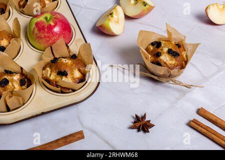 Hausgemachte Muffins mit Äpfeln, Rosinen und Zimtstangen. Auf hellem Hintergrund Stockfoto